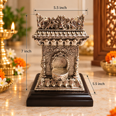 An ornate silver-toned miniature diya holder with a black base, shown on a marble-like surface with dimension labels indicating 7 inch height and 5.5 inch width/depth.