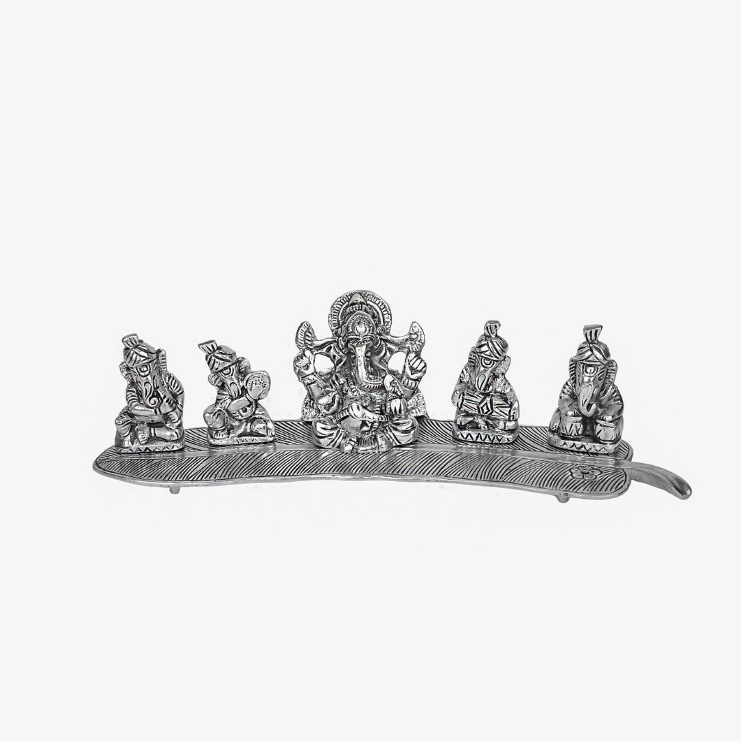 Instrument playing 5 ganesha idol on a leaf