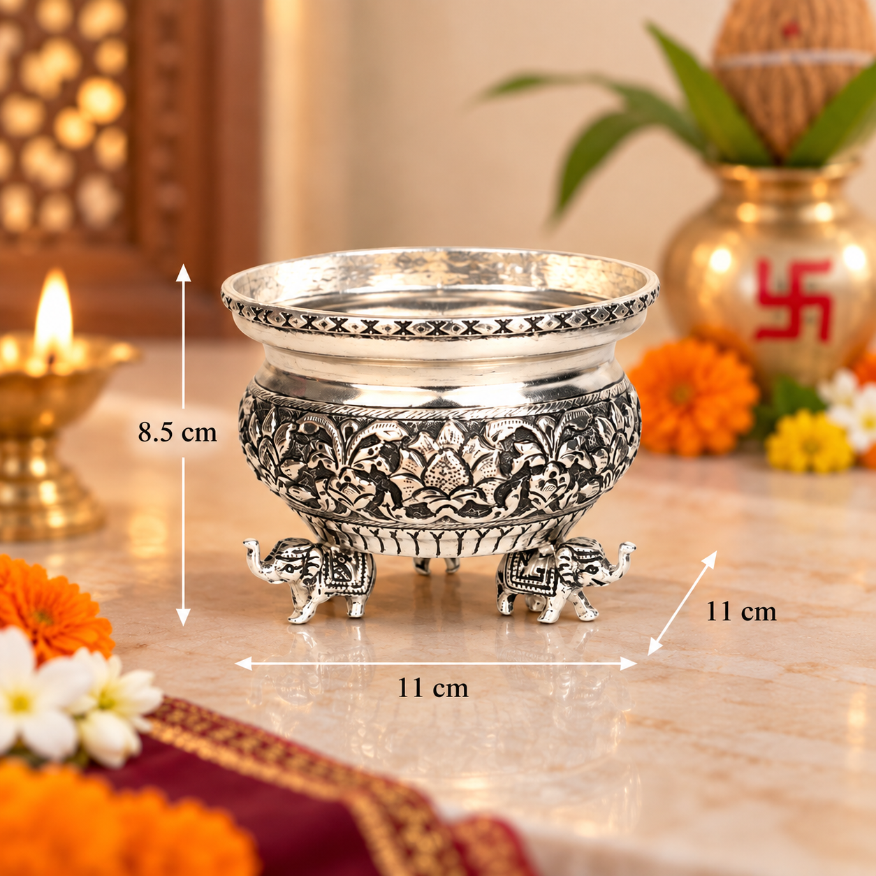 An ornate silver-toned metal incense burner with elephant feet and intricate floral relief work, shown on a marble surface with dimension arrows and labels indicating 8.5 cm height, 11 cm width, and 11 cm depth.