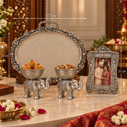 Ornate silver-toned decorative set on a marble table, including an oval tray, two elephant-shaped bowls holding sweets, and a framed picture. White dimension lines and labels show measurements: 37 cm width, 21 cm height, and 13 cm frame width.