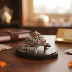 Decorative turtle figurine with jewelry on a wooden surface