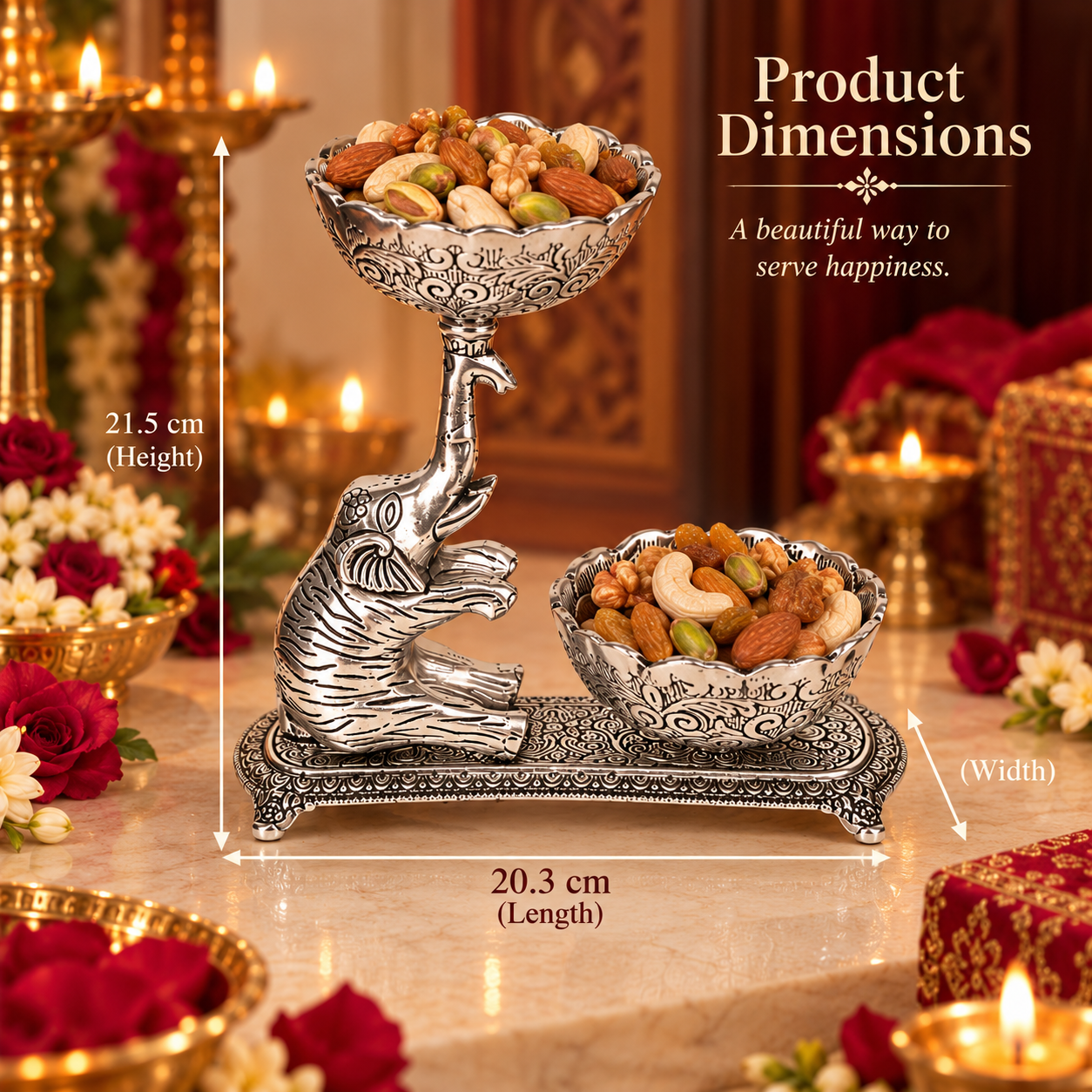 Silver-toned elephant-shaped serving tray filled with nuts and fruits, shown on a decorated table with candles and flowers. White dimension lines and text indicate product measurements: 21.