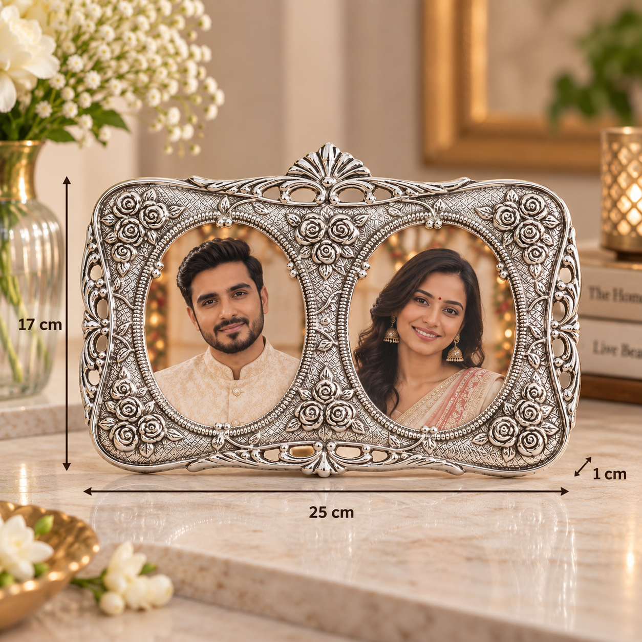 An ornate silver double-photo frame with detailed floral carvings, shown on a marble countertop with dimension lines indicating 25 cm width, 17 cm height, and 1 cm depth. The photos inside the frame show a man and a woman.