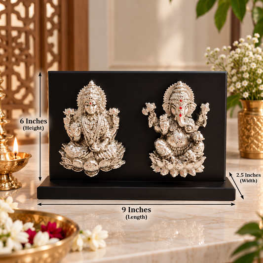 A black rectangular decorative plaque or box featuring two silver-toned Hindu deity statues, shown on a marble surface with dimension arrows and labels indicating 9 inches length, 6 inches height, and 2.5 inches width.