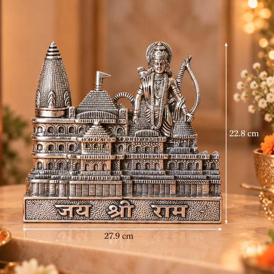 An ornate silver-toned metal sculpture of Lord Shri Ram standing before a detailed temple structure, with height and width measurements overlaid on the image. The piece is displayed on a table with warm decorative lighting, flowers, and a lit candle in the background.