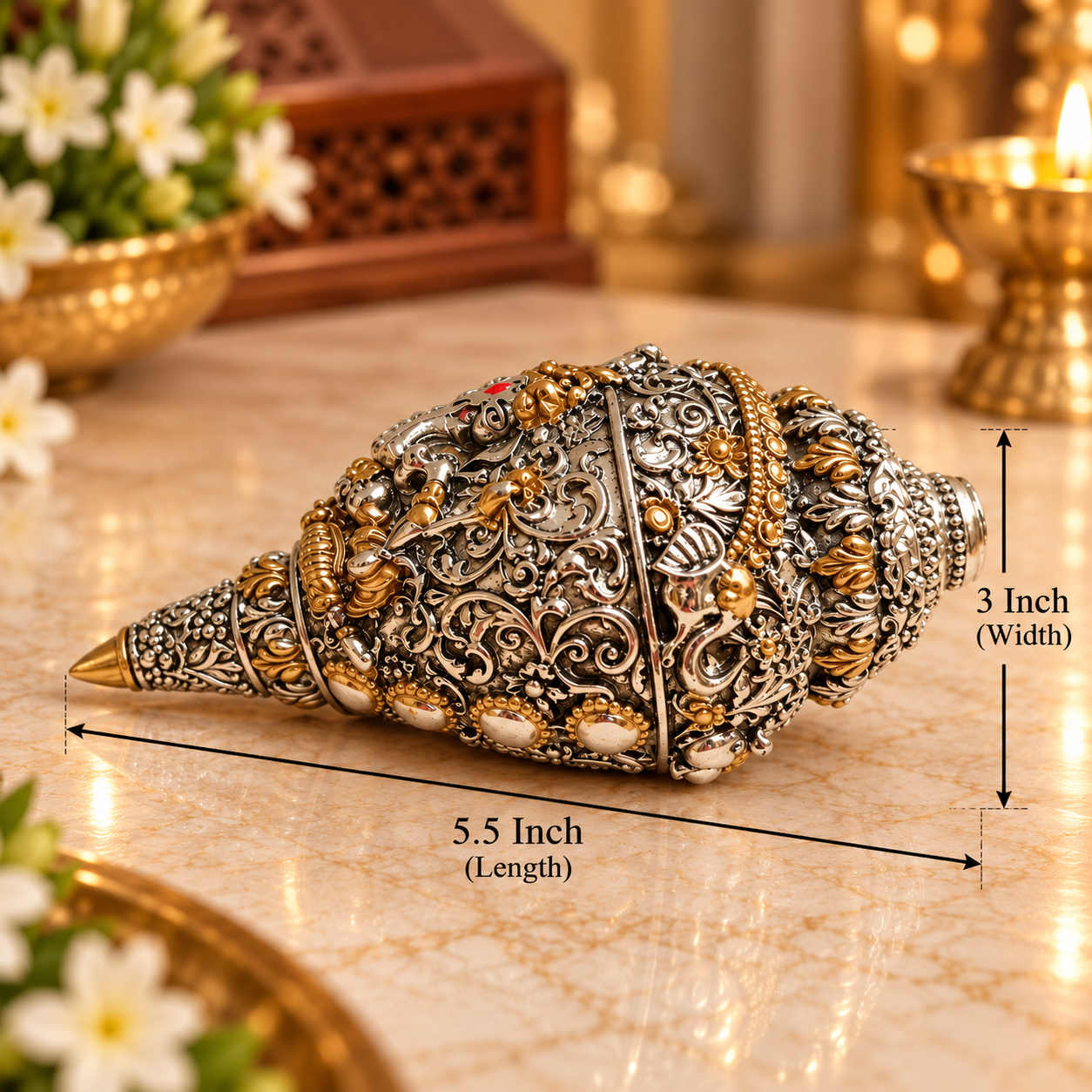 An ornate silver-toned shell-shaped decorative object with intricate gold and white detailing, shown on a marble surface with dimension lines indicating 5.5 inch length and 3 inch width.